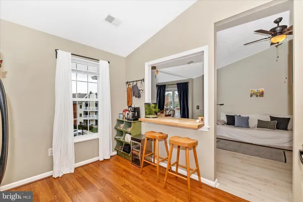 a view of empty room with wooden floor and fan
