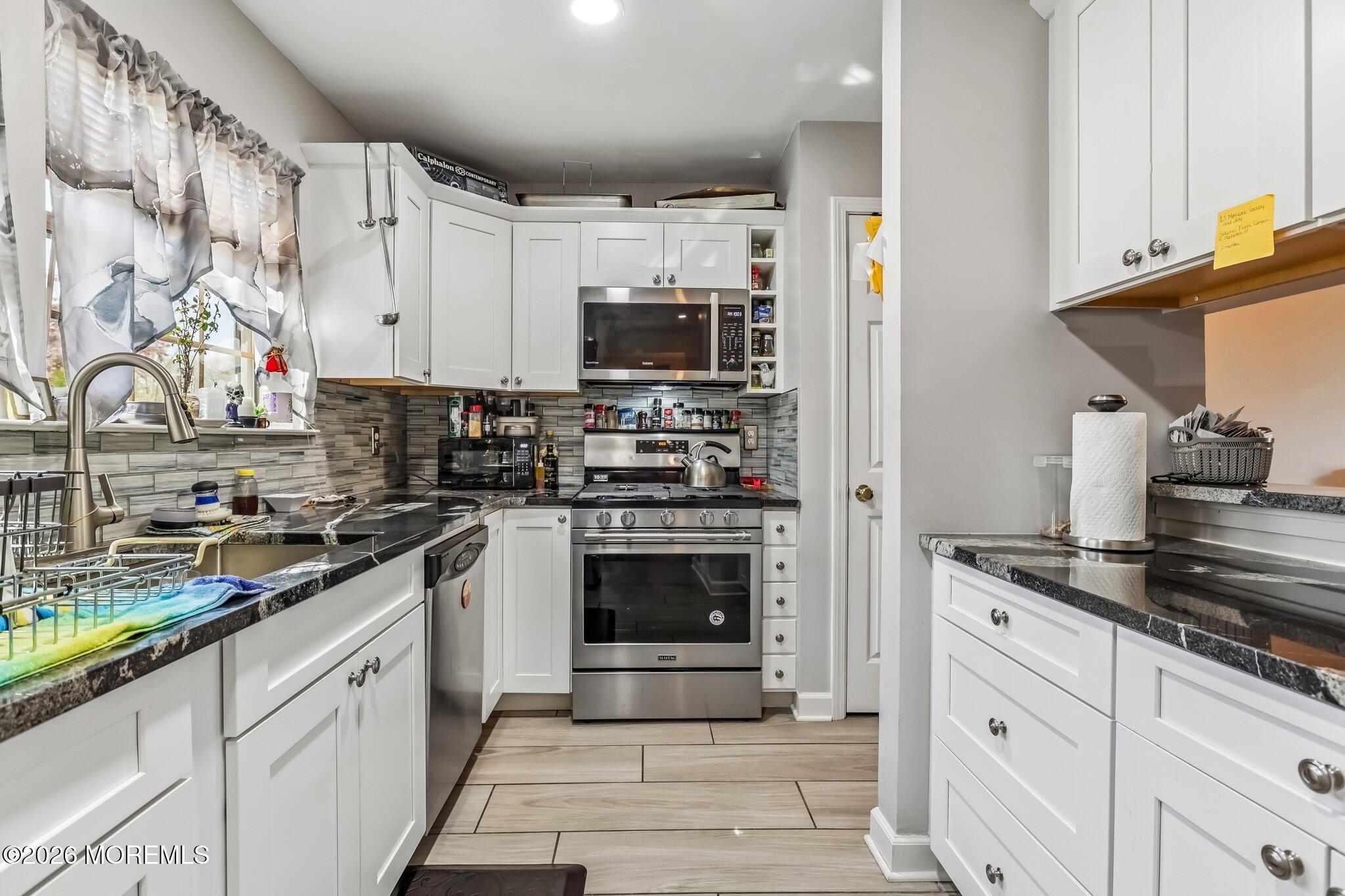 197 Azalea Circle Jackson, NJ 08527 - Photo 14 of 33 a kitchen with stainless steel appliances granite countertop a stove and a sink
