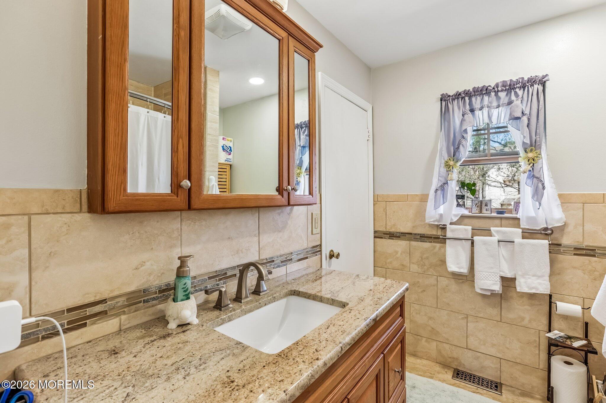 197 Azalea Circle Jackson, NJ 08527 - Photo 26 of 33 a bathroom with a granite countertop sink a mirror and next to a window