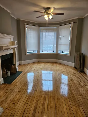 a view of empty room with wooden floor and fireplace