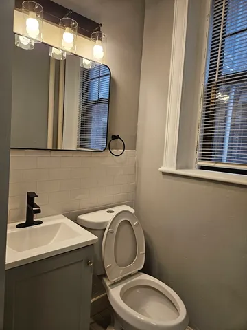 a bathroom with a toilet sink and mirror