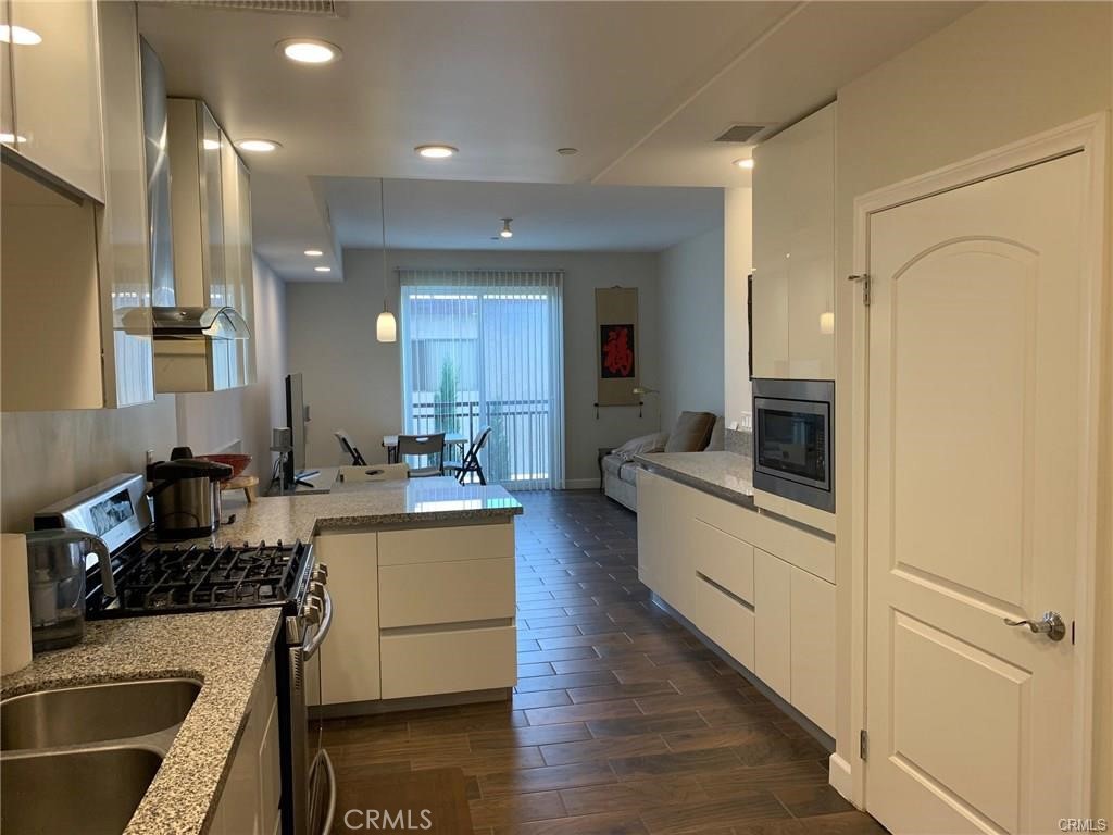 28 North 3rd Street, Unit B210 Alhambra, CA 91801 - Photo 9 of 9 a large kitchen with a counter top space a sink stainless steel appliances and cabinets