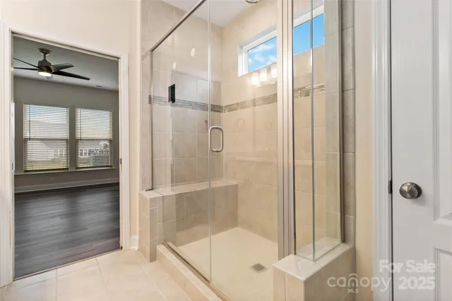 a bathroom with a glass shower door and a window