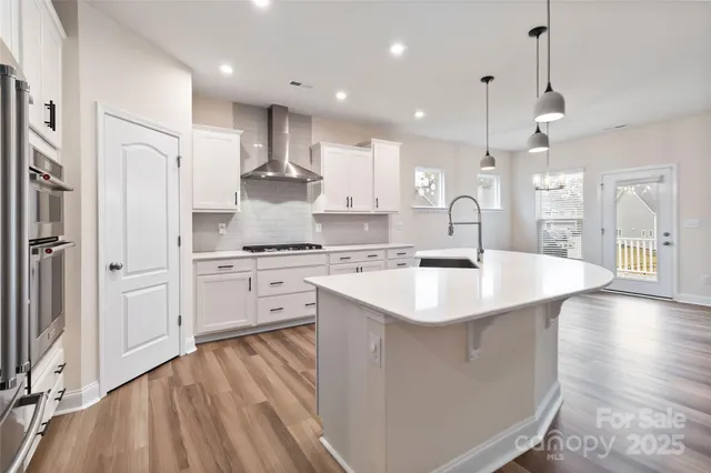 a large kitchen with stainless steel appliances kitchen island granite countertop a sink refrigerator and cabinets