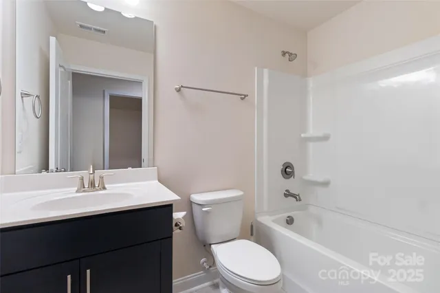 a bathroom with a sink a toilet a mirror and shower