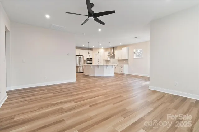 a view of a kitchen with wooden floor and a window