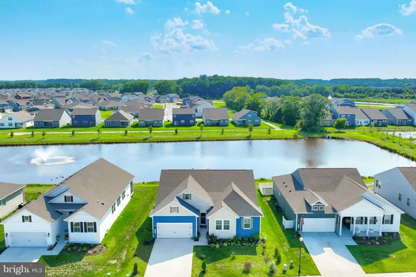 an aerial view of a house with a garden and lake view