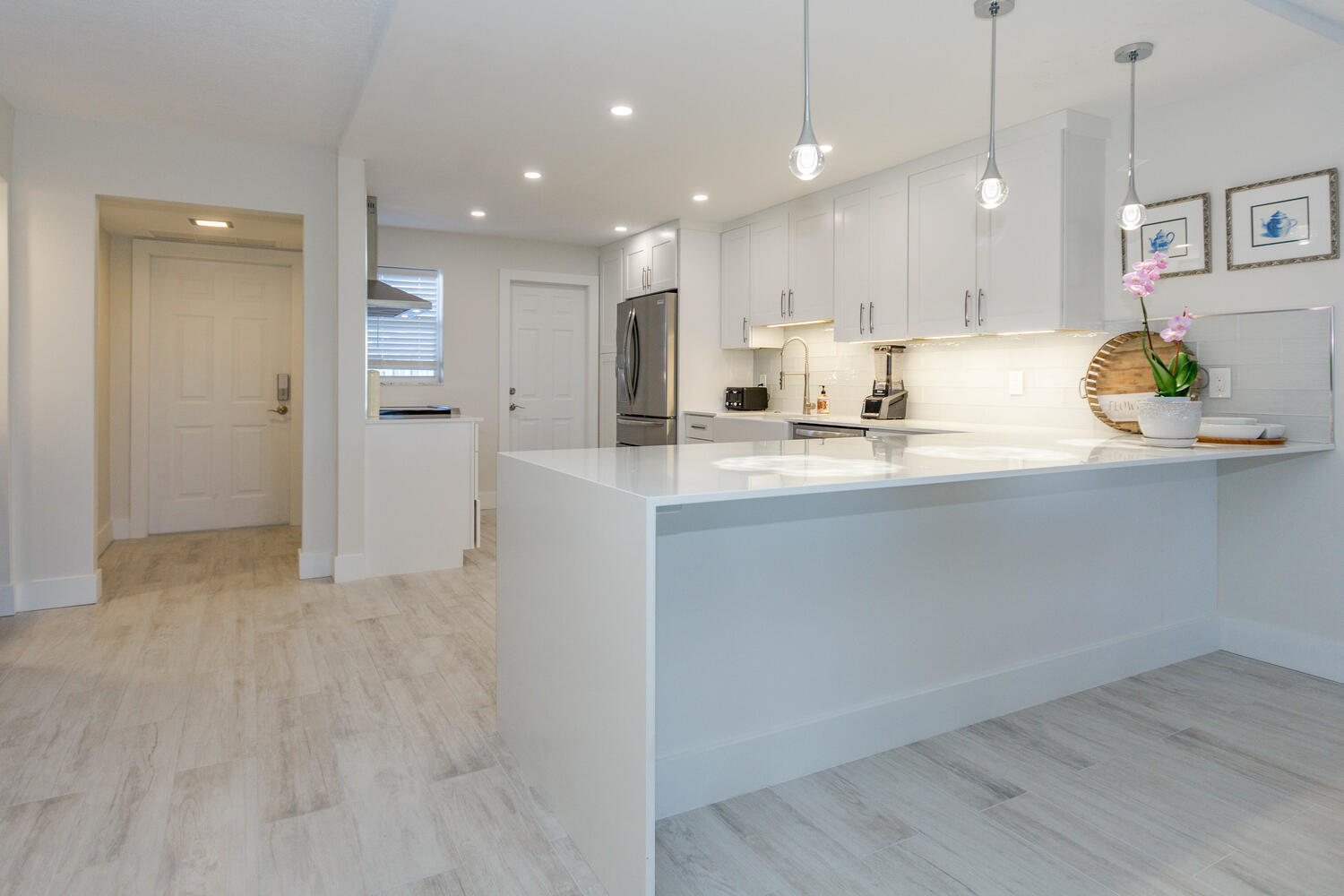 120 Celestial Way, Unit 302 Juno Beach, FL 33408 - Photo 5 of 55 a kitchen with kitchen island a sink appliances and cabinets