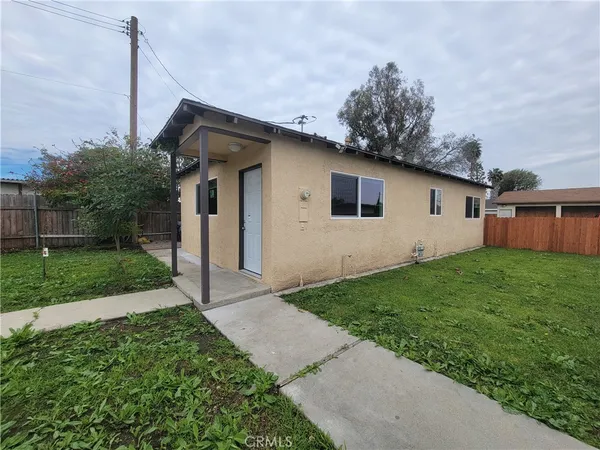 a view of an empty room with wooden floor and closet
