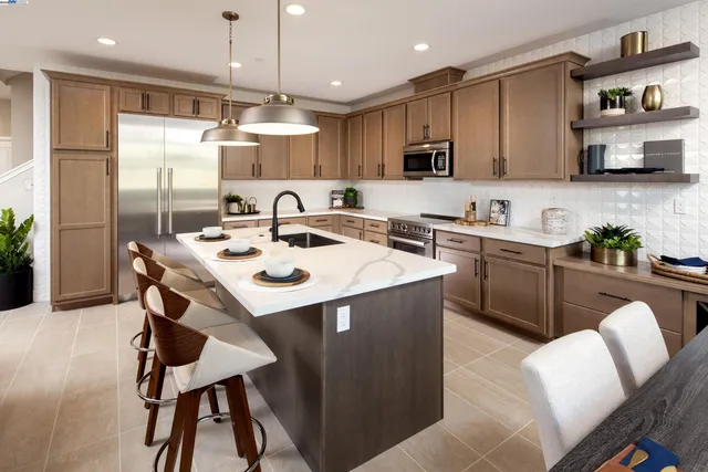 a kitchen with stainless steel appliances granite countertop a table chairs sink refrigerator and microwave