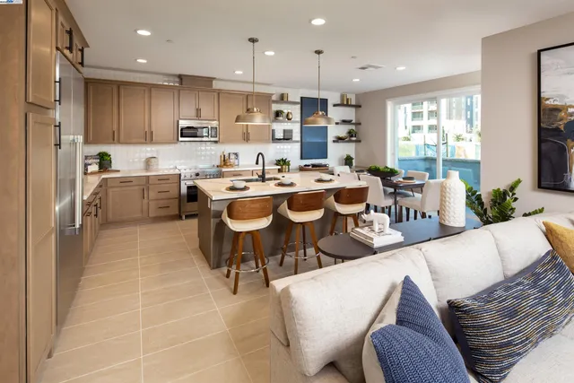 a large dining hall with stainless steel appliances kitchen island granite countertop a table and chairs