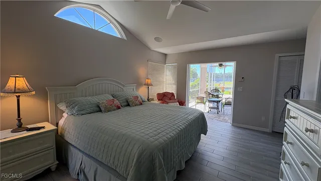 a bedroom with bed a lamp and a large window