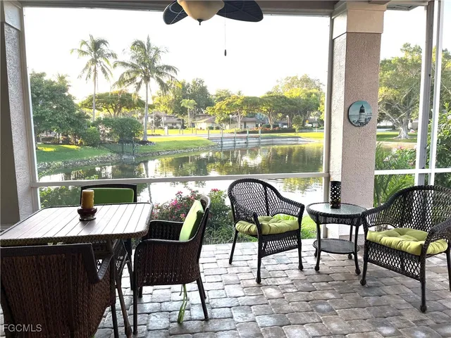 a view of a chairs and table in patio with a lake view