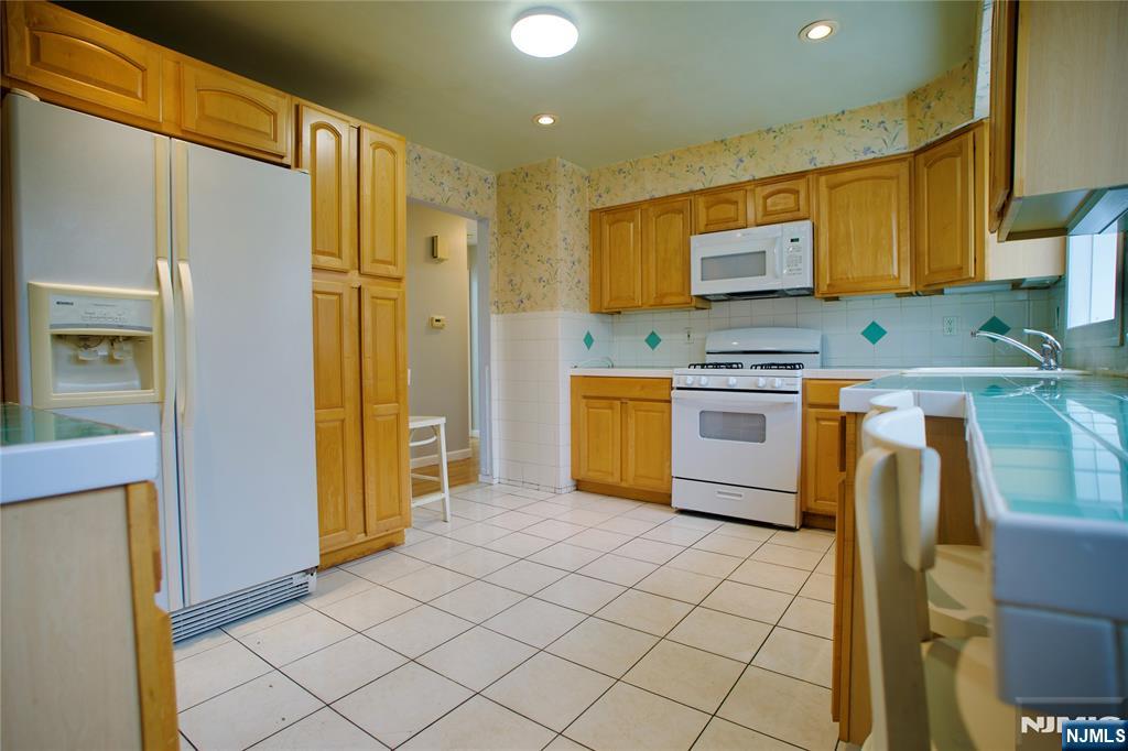 524 Studio Road, Unit 1 Ridgefield, NJ 07657 - Photo 14 of 44 a kitchen with stainless steel appliances granite countertop a stove a sink and a refrigerator