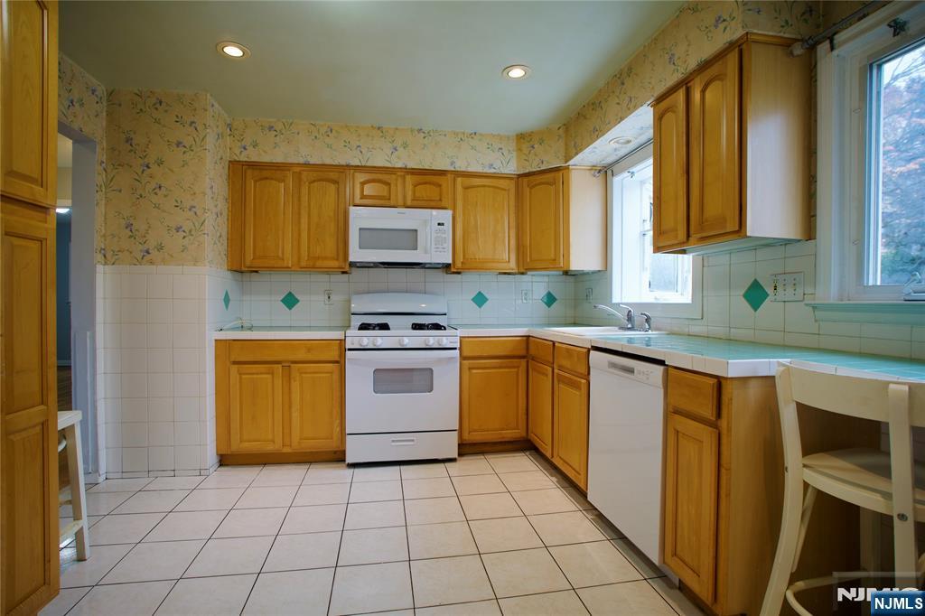 524 Studio Road, Unit 1 Ridgefield, NJ 07657 - Photo 15 of 44 a kitchen with stainless steel appliances granite countertop a stove a sink and a microwave