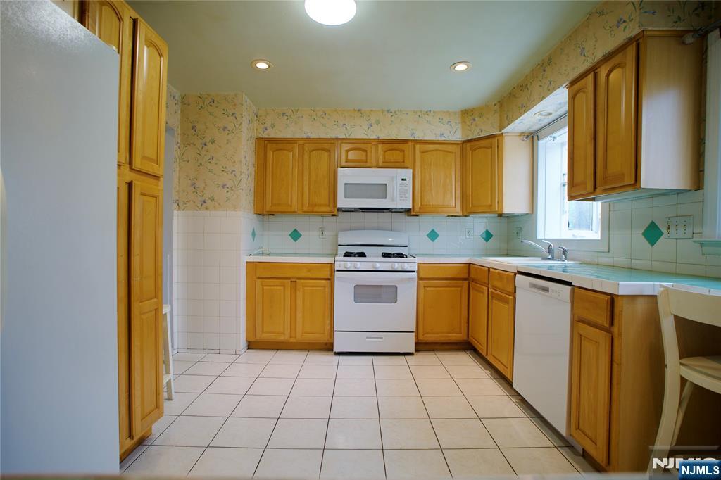524 Studio Road, Unit 1 Ridgefield, NJ 07657 - Photo 16 of 44 a kitchen with a sink a stove top oven cabinets and a window