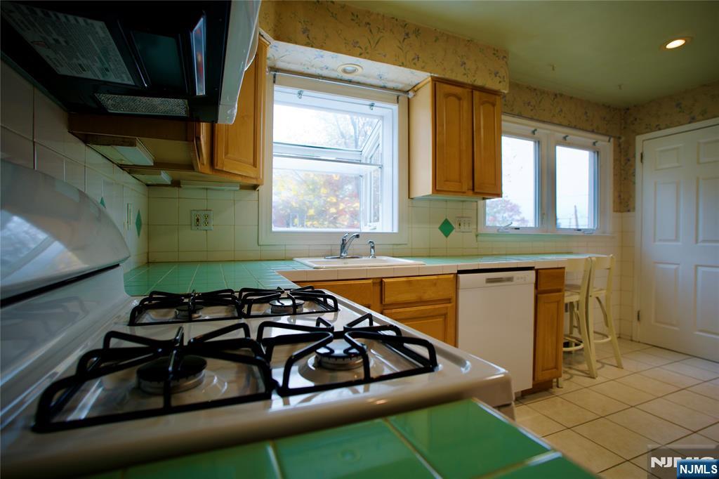524 Studio Road, Unit 1 Ridgefield, NJ 07657 - Photo 17 of 44 a kitchen with a sink a stove and a microwave