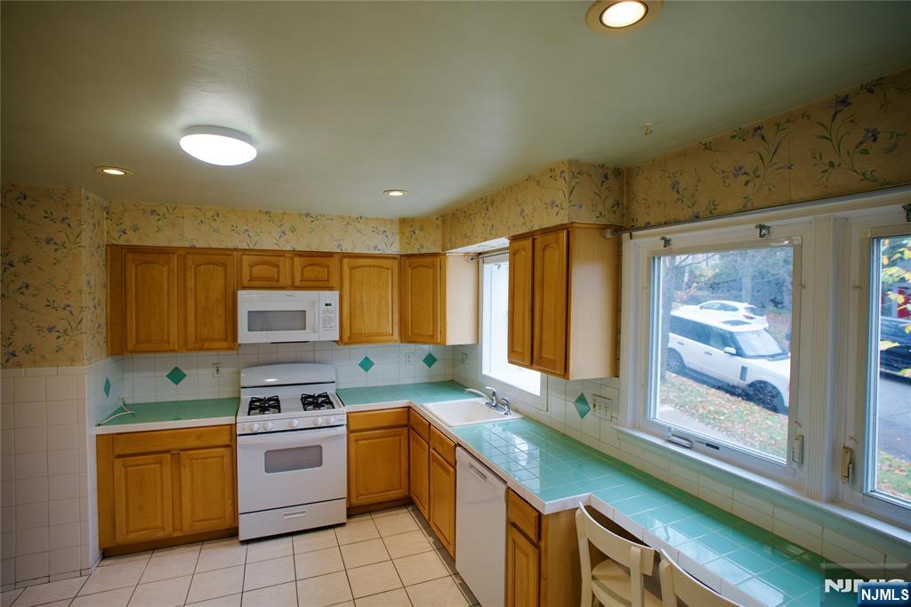 524 Studio Road, Unit 1 Ridgefield, NJ 07657 - Photo 19 of 44 a kitchen with stainless steel appliances granite countertop a sink and a stove top oven