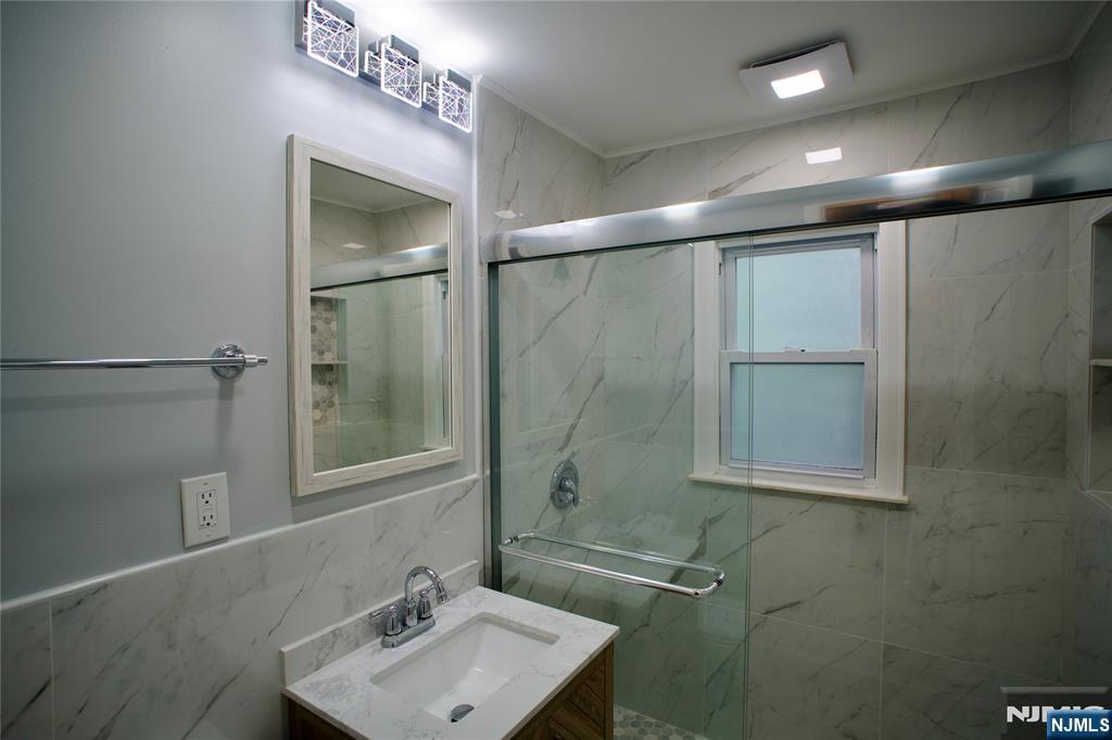 524 Studio Road, Unit 1 Ridgefield, NJ 07657 - Photo 33 of 44 a bathroom with a sink mirror and a shower