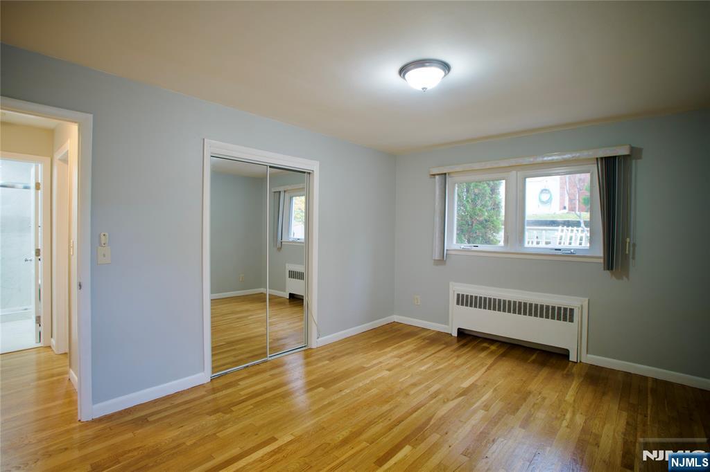 524 Studio Road, Unit 1 Ridgefield, NJ 07657 - Photo 39 of 44 an empty room with wooden floor and windows