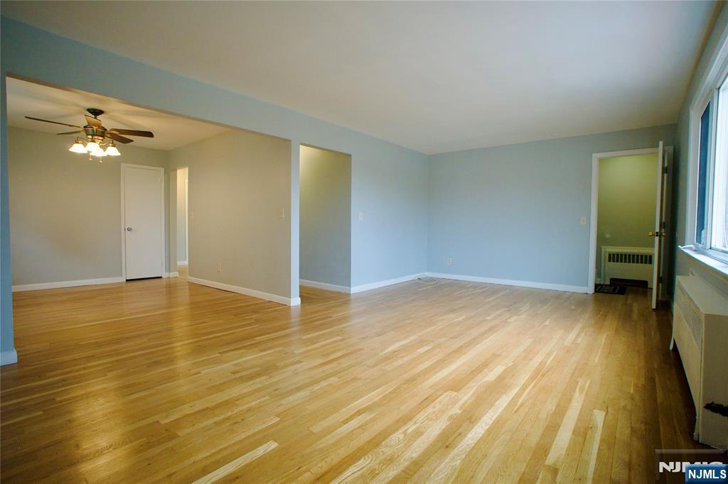 524 Studio Road, Unit 1 Ridgefield, NJ 07657 - Photo 8 of 44 an empty room with wooden floor and a bathroom