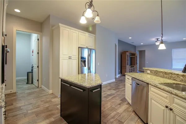 a kitchen with stainless steel appliances granite countertop a sink and a refrigerator