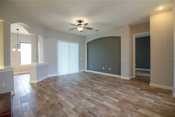 a view of a livingroom with a ceiling fan window and hardwood floor