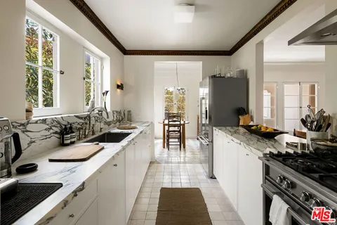 a large kitchen with a sink and cabinets
