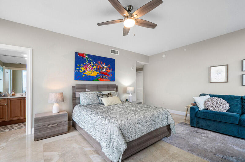 4600 North Ocean Drive, Unit 1603 Singer Island, FL 33404 - Photo 17 of 43 a bedroom with a bed and a chandelier