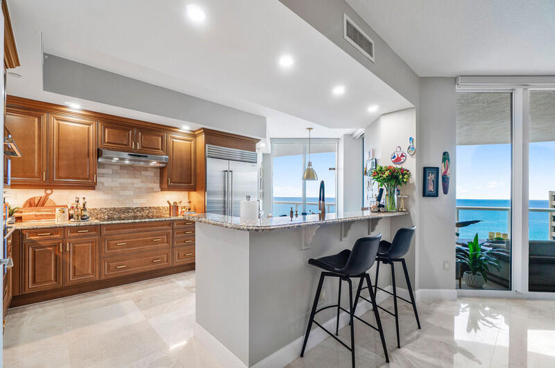4600 North Ocean Drive, Unit 1603 Singer Island, FL 33404 - Photo 4 of 43 a kitchen with counter top space cabinets and stainless steel appliances
