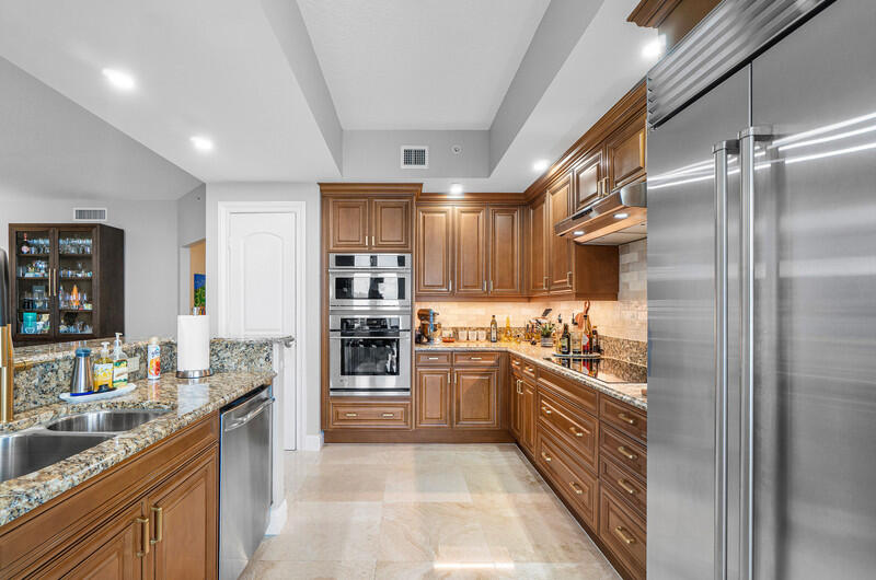 4600 North Ocean Drive, Unit 1603 Singer Island, FL 33404 - Photo 5 of 43 a large kitchen with stainless steel appliances kitchen island granite countertop a refrigerator and a sink
