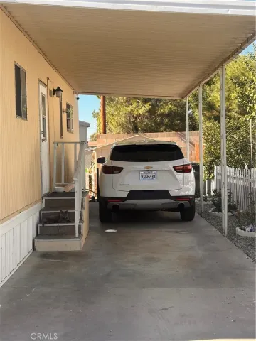 a view of a patio with table and chairs with wooden floor and fence