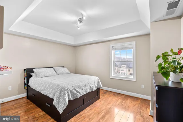 a bedroom with a large bed chandelier and a window