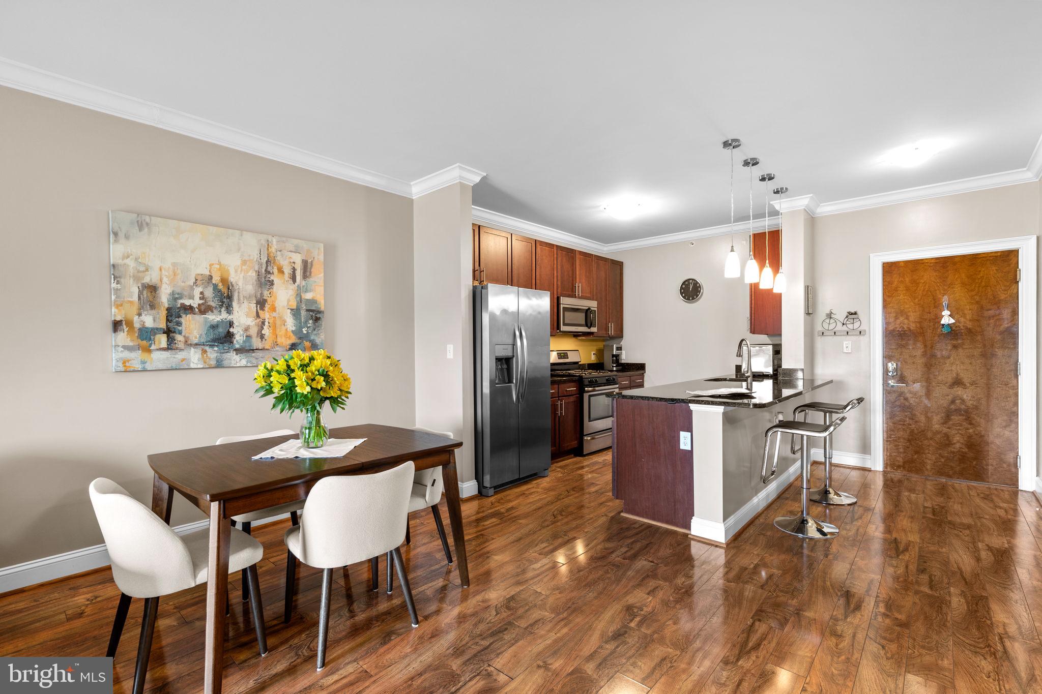 6301 Edsall Road, Unit 500 Alexandria, VA 22312 - Photo 5 of 30 a kitchen with stainless steel appliances kitchen island granite countertop a refrigerator a stove a sink a dining table and chairs with wooden floor