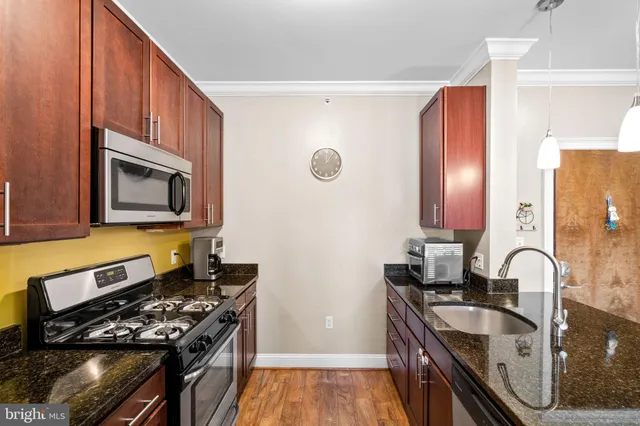 a kitchen with granite countertop stainless steel appliances and a sink