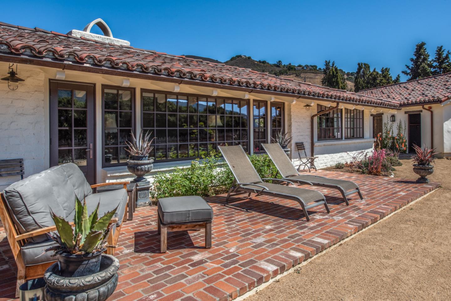 34 Rancho Road Carmel Valley, CA 93924 - Photo 22 of 22 a front view of a house with patio furniture and potted plants