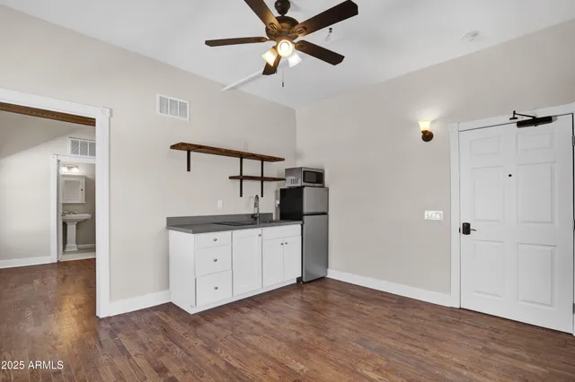 a kitchen with a refrigerator and ceiling fan