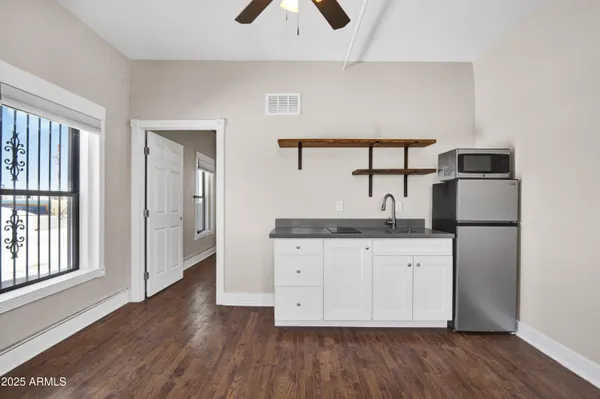 a kitchen with stainless steel appliances granite countertop a refrigerator a sink and white cabinets