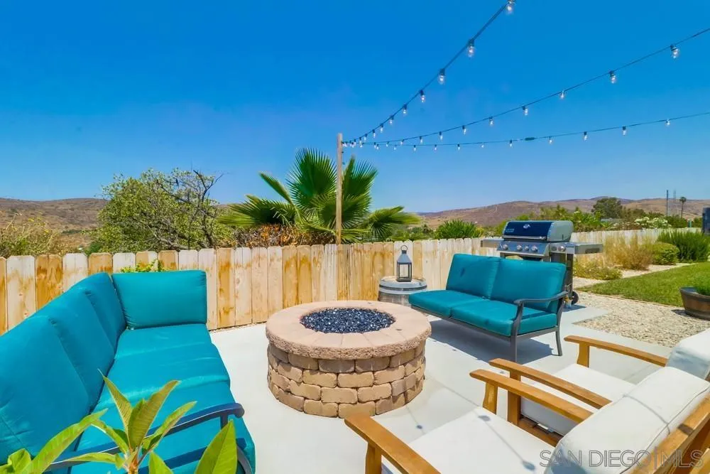 10544 Cadwell Road Santee, CA 92071 - Photo 23 of 27 a view of a patio with couches chairs potted plants and a palm tree