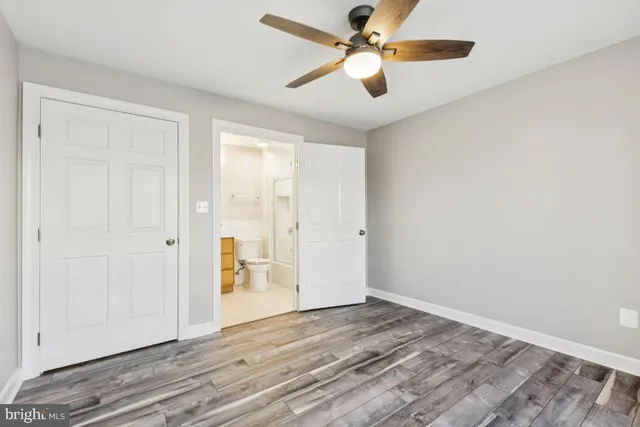 an empty room with wooden floor a ceiling fan and closet