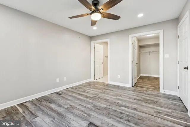 a view of an empty room and window with a chandelier fan