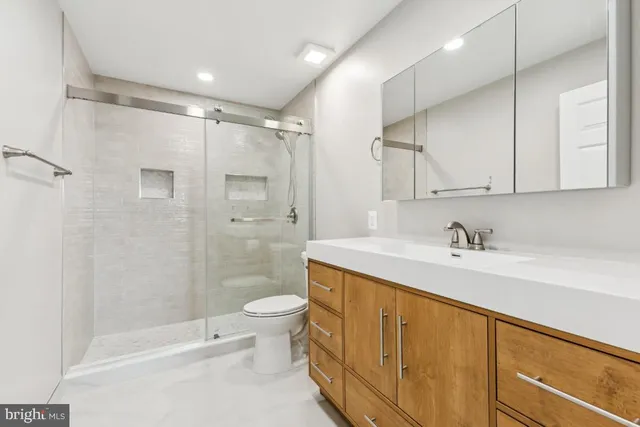 a bathroom with a sink a toilet and shower