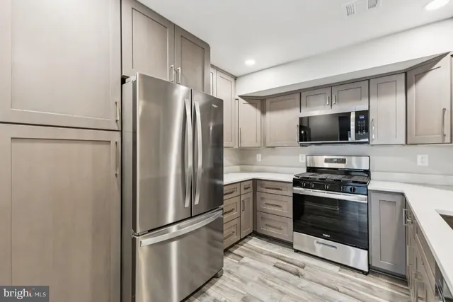 a kitchen with stainless steel appliances a refrigerator stove and microwave