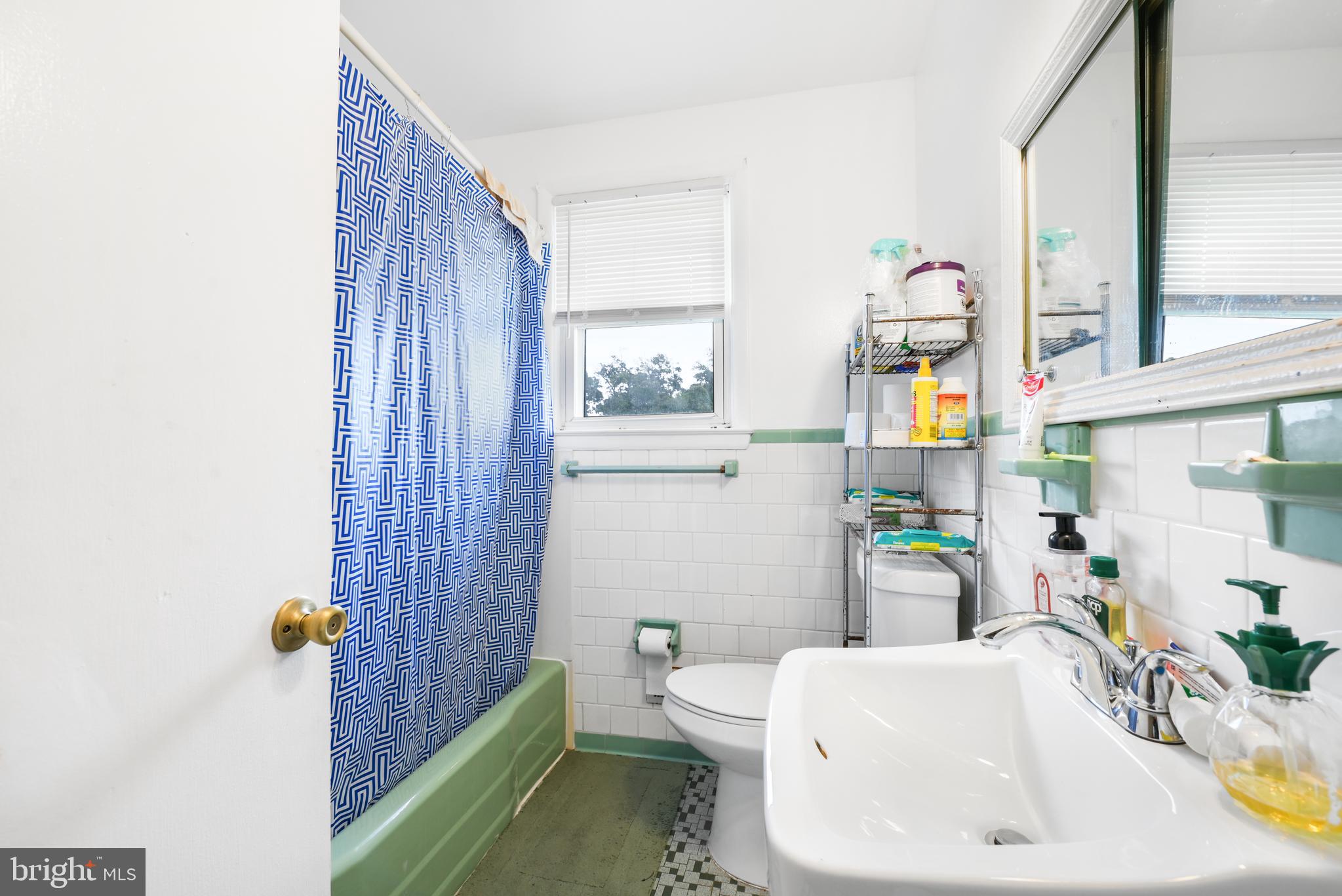 6102 Shady Spring Avenue Baltimore, MD 21237 - Photo 11 of 26 a bathroom with a sink toilet and shower