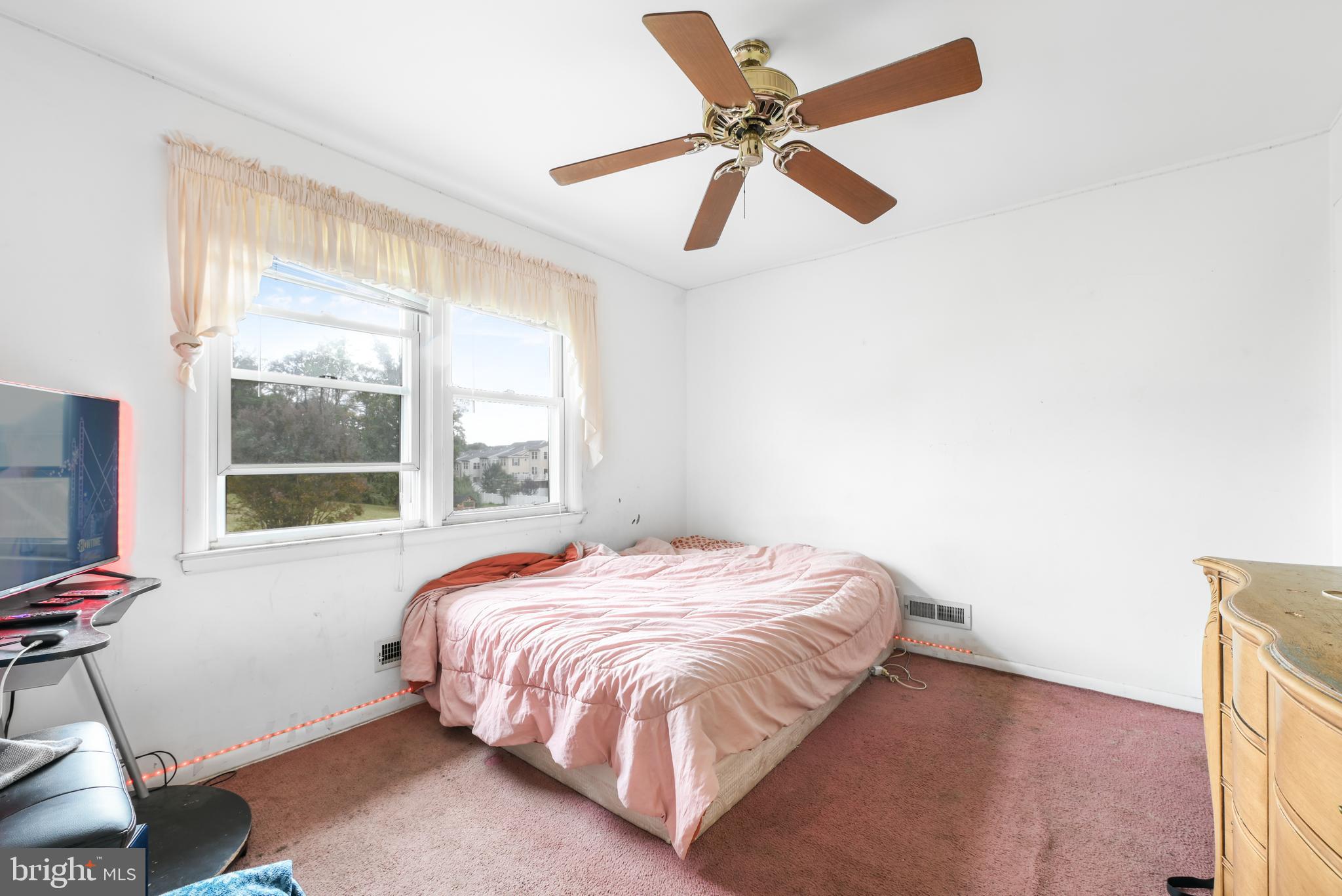6102 Shady Spring Avenue Baltimore, MD 21237 - Photo 12 of 26 a bed sitting in a bedroom next to a window
