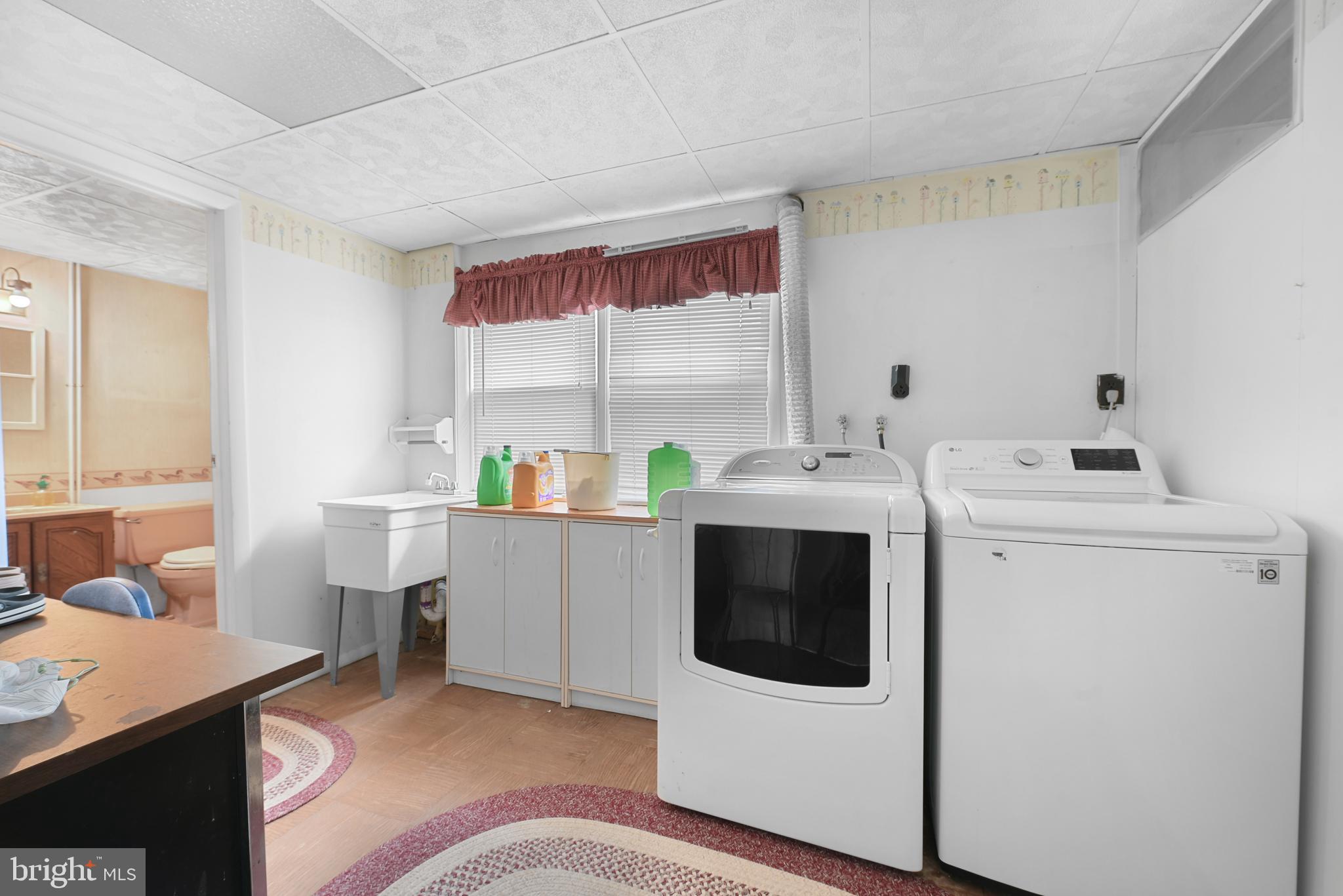 6102 Shady Spring Avenue Baltimore, MD 21237 - Photo 17 of 26 a utility room with cabinets dryer and washer