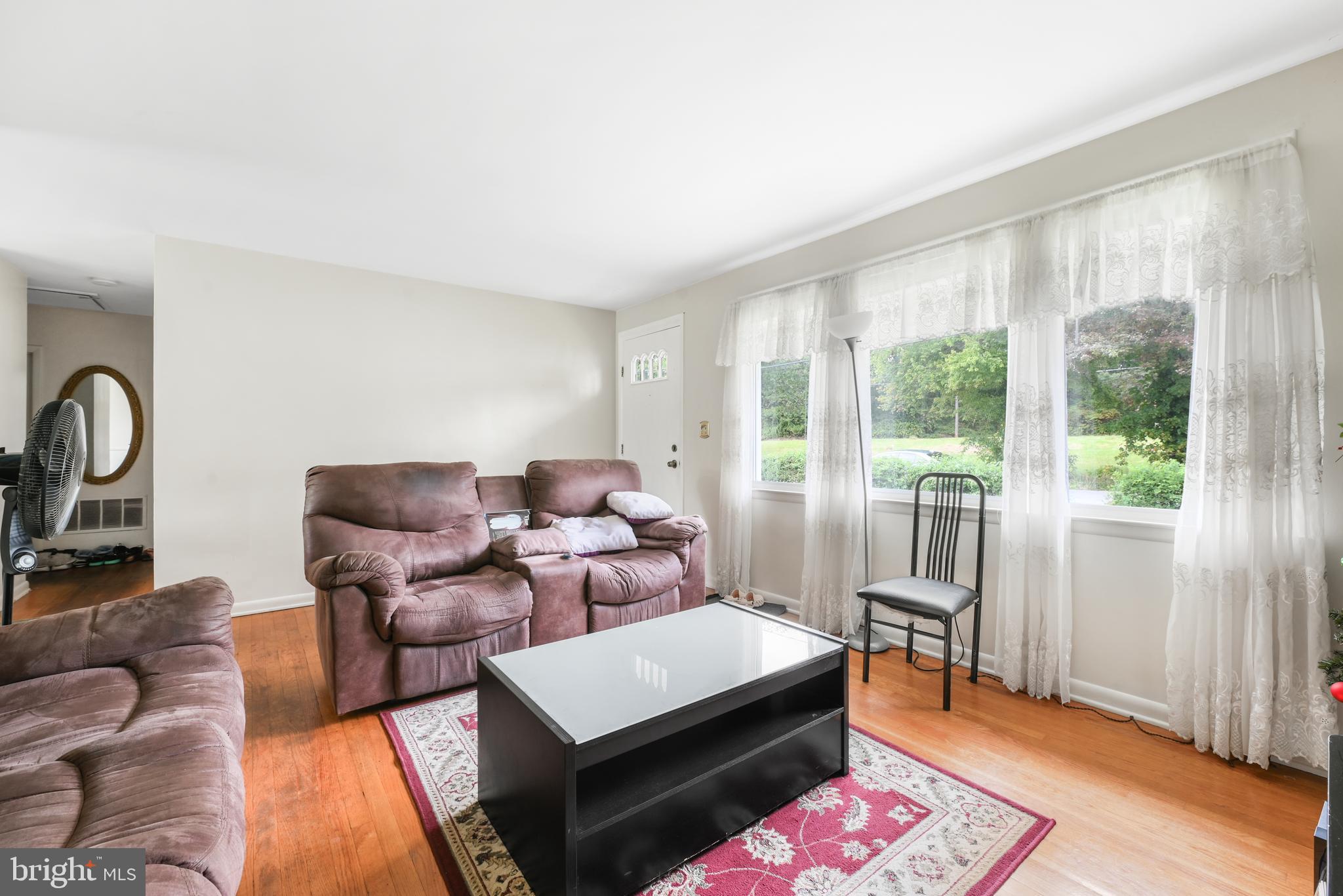 6102 Shady Spring Avenue Baltimore, MD 21237 - Photo 5 of 26 a living room with furniture a flat screen tv and a large window