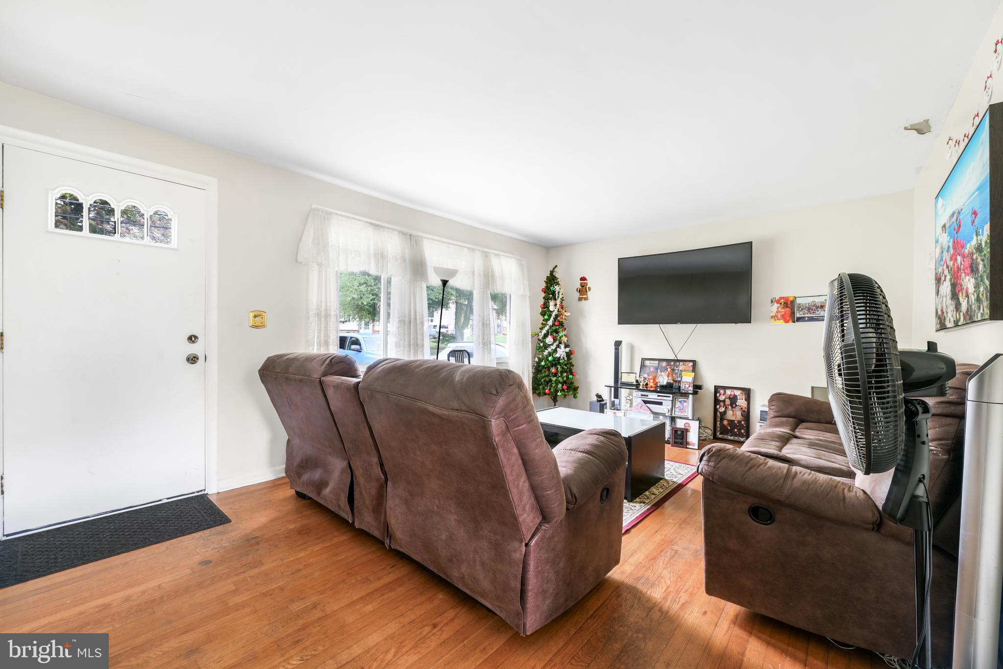 6102 Shady Spring Avenue Baltimore, MD 21237 - Photo 6 of 26 a living room with furniture and a flat screen tv