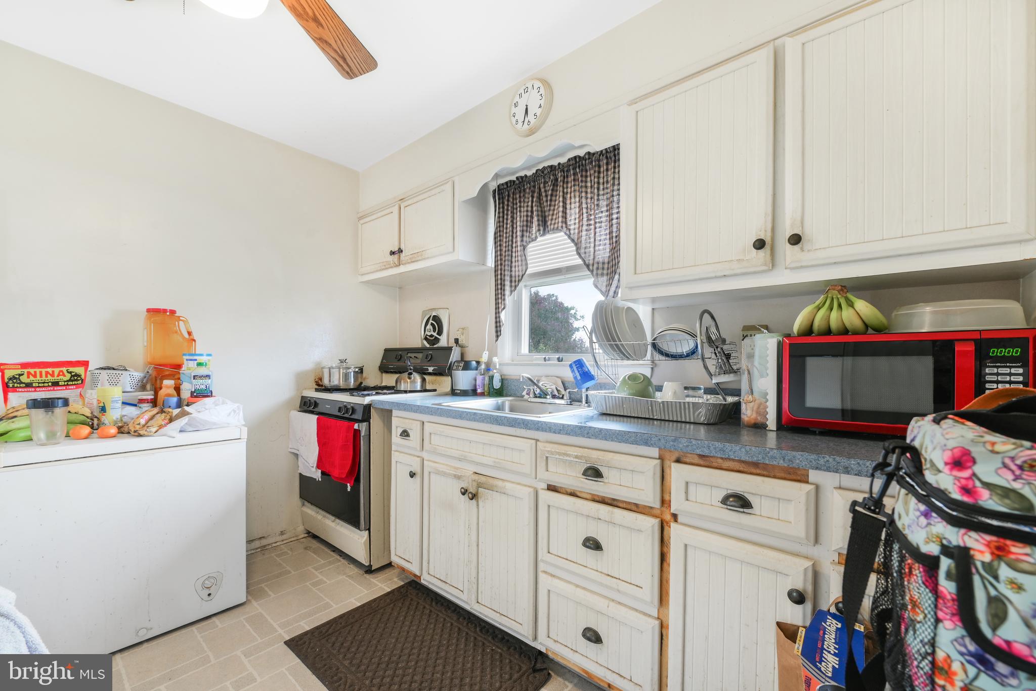 6102 Shady Spring Avenue Baltimore, MD 21237 - Photo 8 of 26 a kitchen with white cabinets and sink