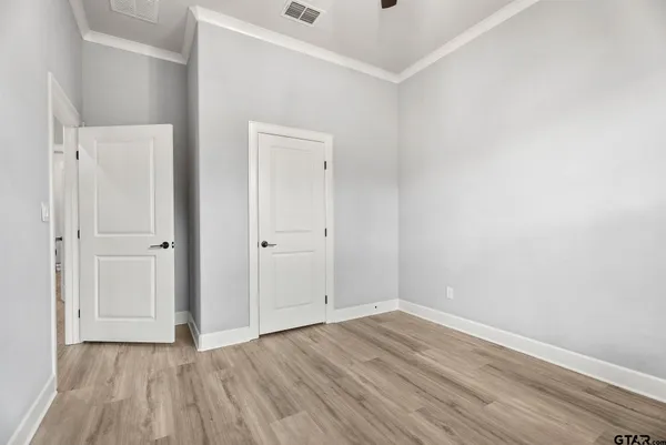 a view of a livingroom with a flat screen tv wooden floor and a ceiling fan